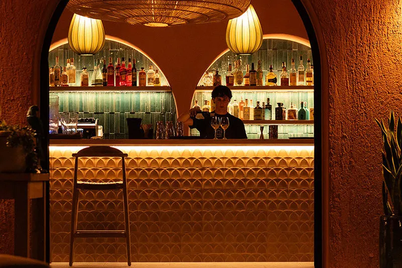 The warmly lit counter of Jaga, the new cocktail bar restaurant of the village