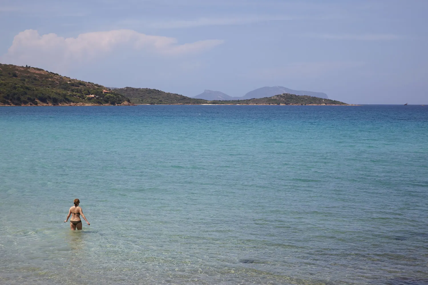 Wading into the clear water of the bay of Porto Taverna