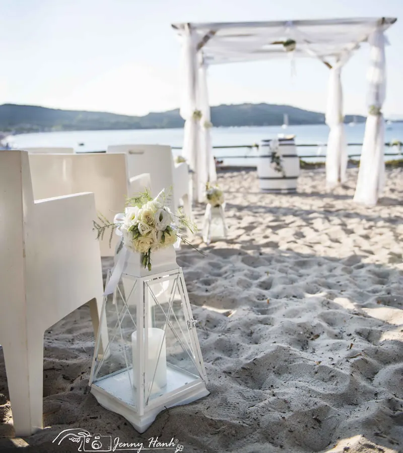 White wedding canopy and chairs set up on the sand of Porto Taverna for a beach ceremony