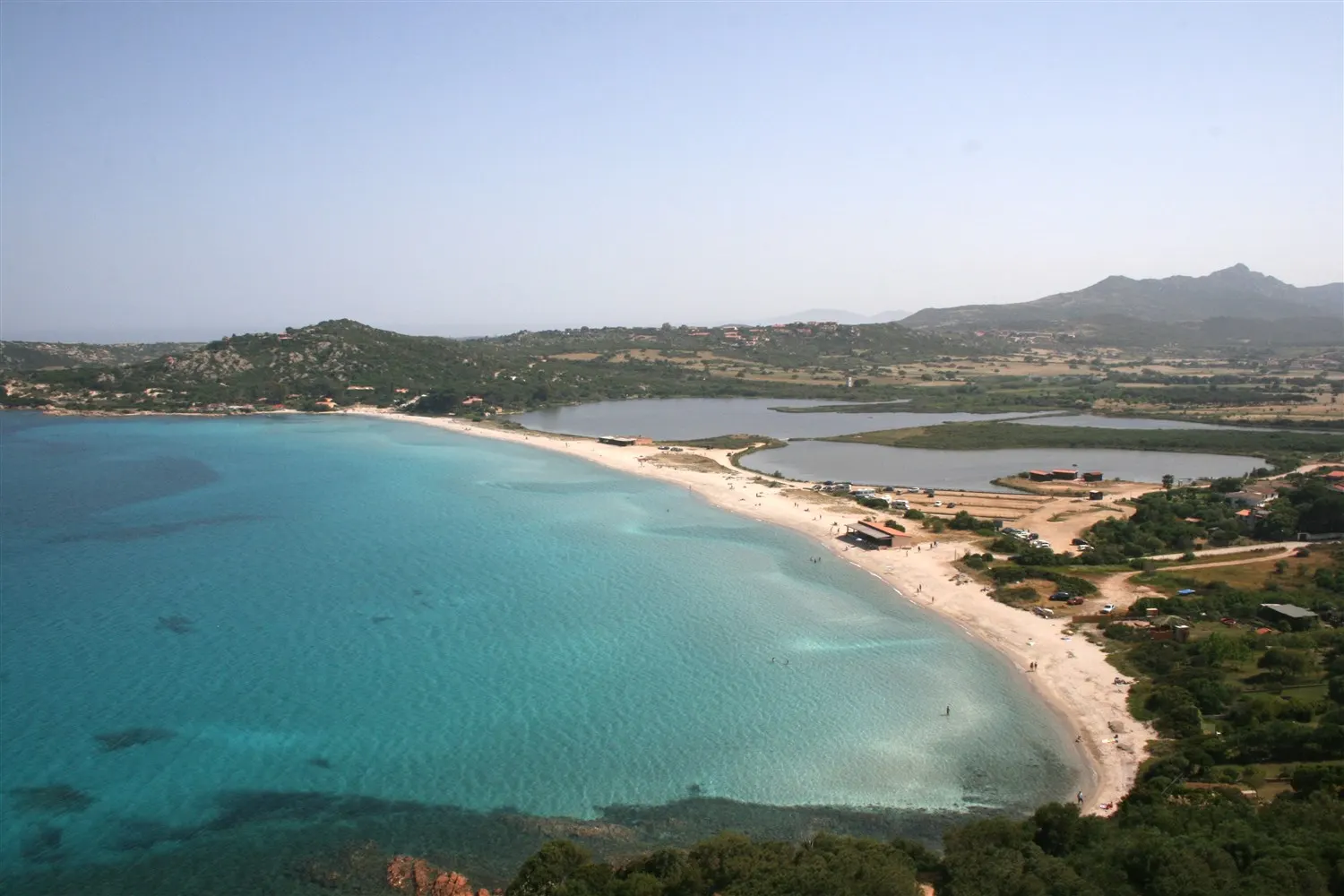 Granite rocks and sand at the edge of Porto Taverna beach