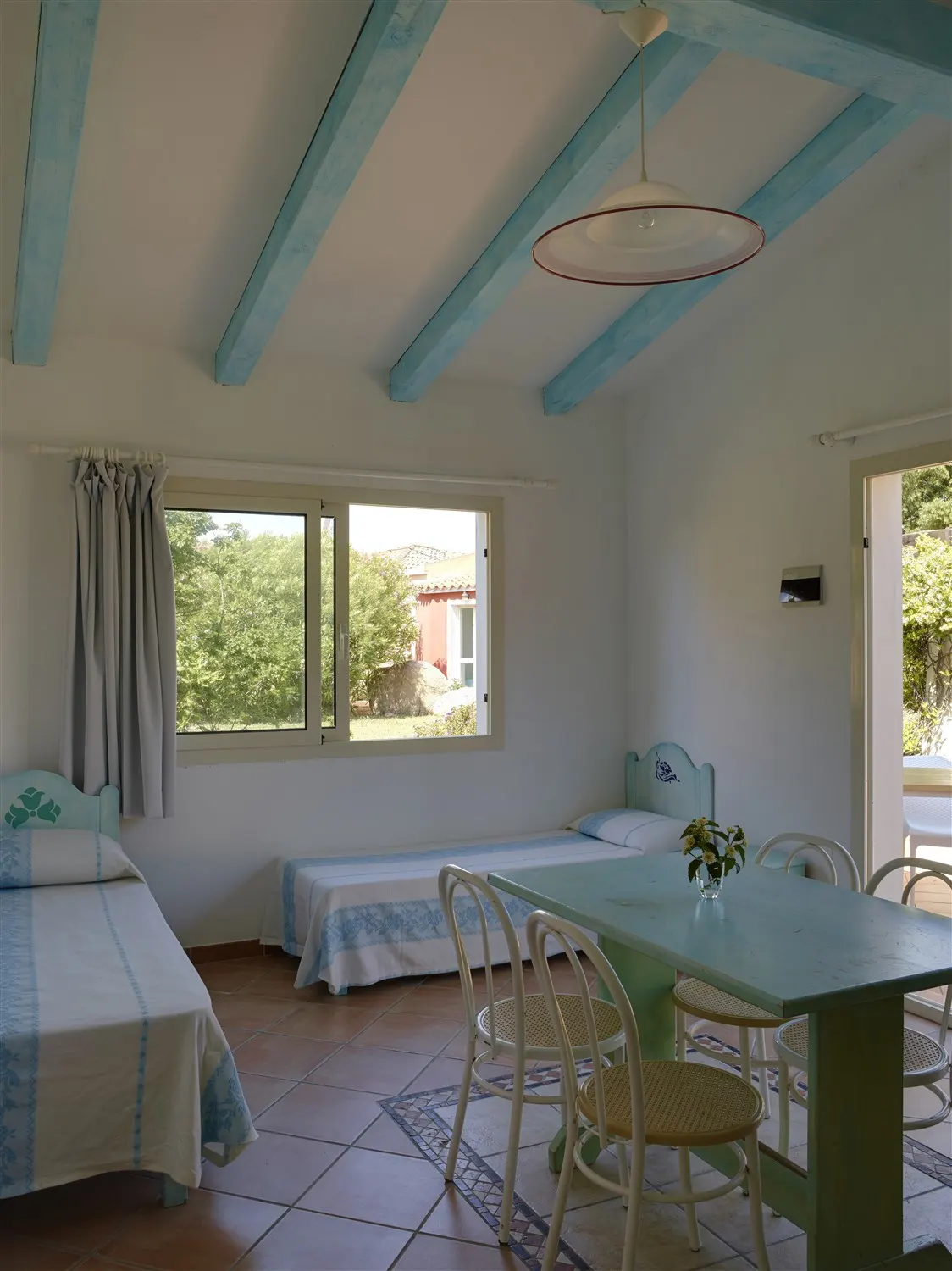 Light-filled living room with pastel blue beams and Sardinian furniture