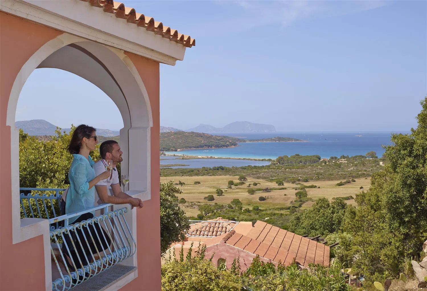 Guests on a balcony overlooking the bay of Porto Taverna